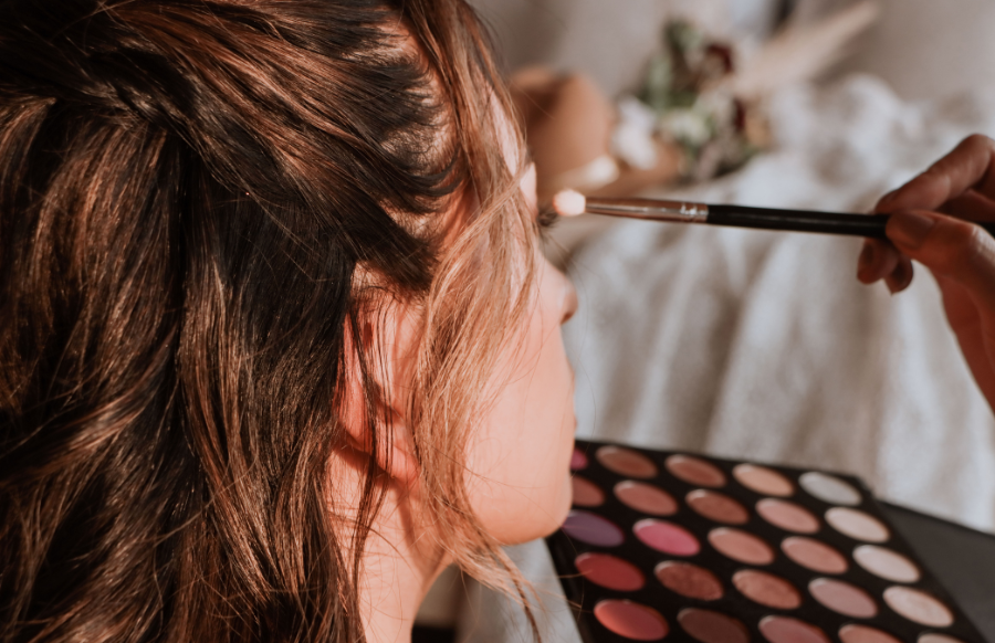 Makeup artist applying eye shadow to a girl