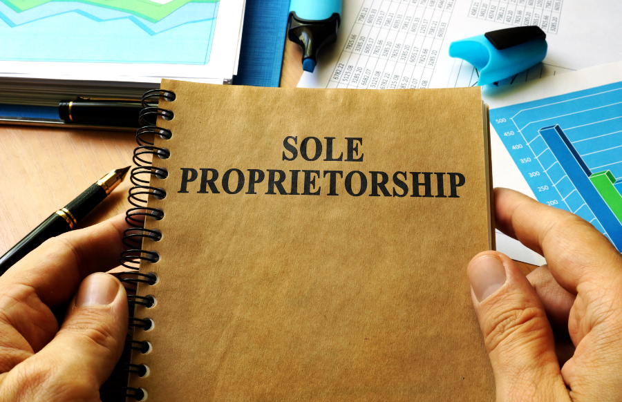 hands holding a book with title sole proprietorship