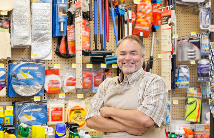 Portrait of a mature salesperson with arms crossed in hardware store