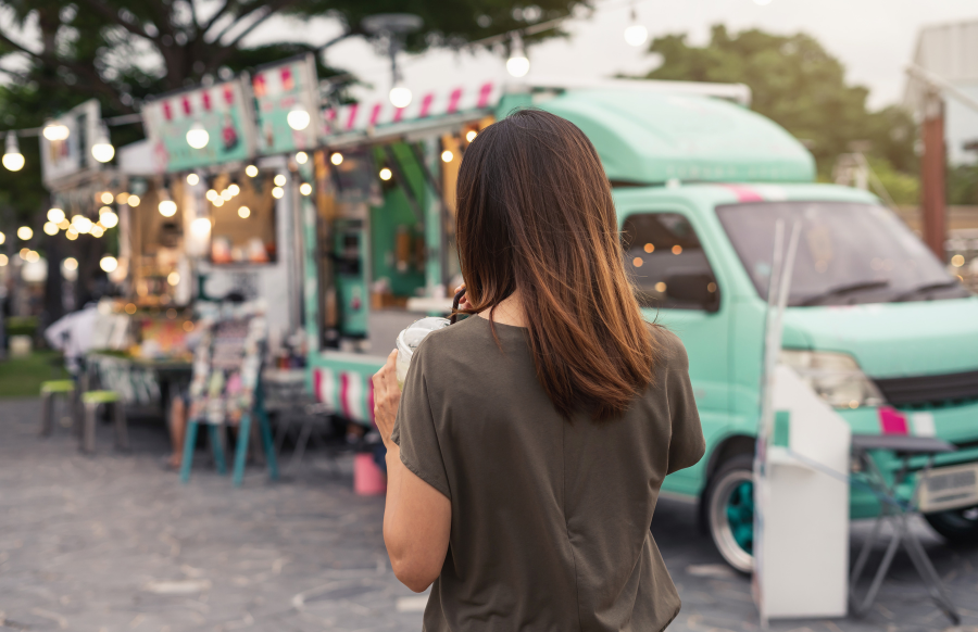 young asian woman walking in the food truck market
